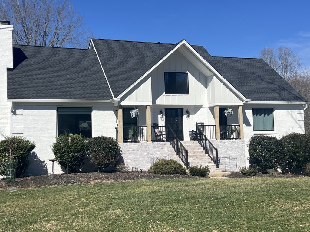 After photos of a roof replacement on a white brick house.