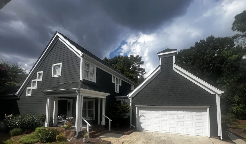 House with new Iron Gray James Hardie Siding and Arctic White Gutters plus downspout