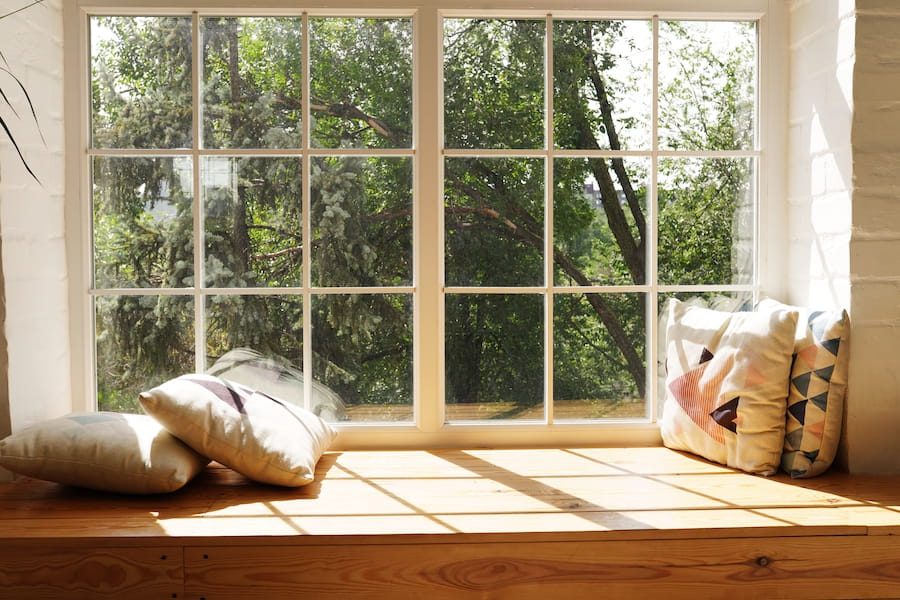 Cozy Window Seat with Pillows and Greenery View