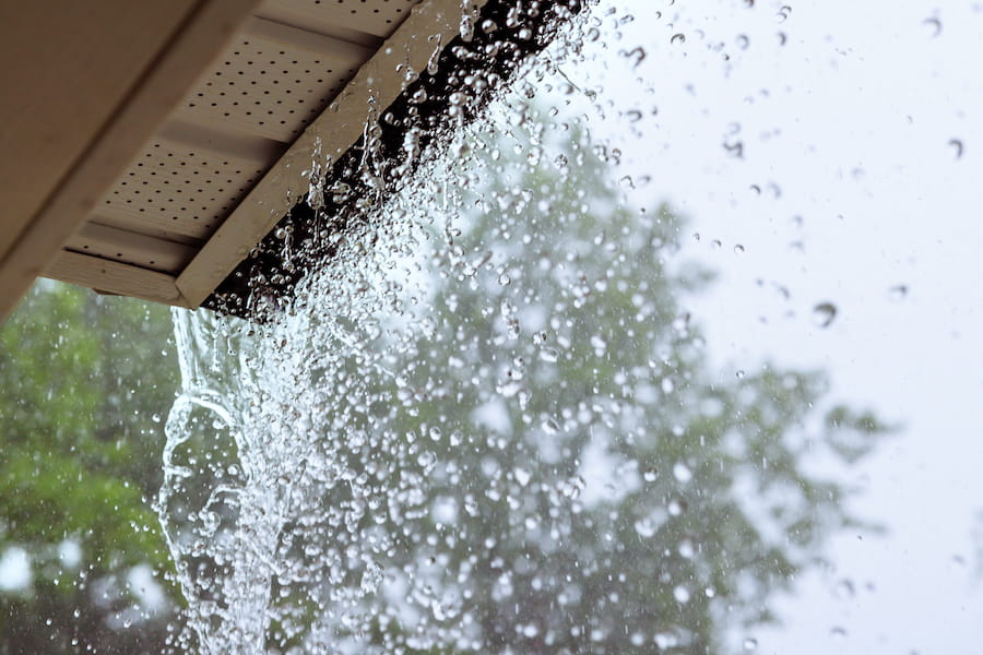 Wet asphalt shingles after rain during a roof replacement